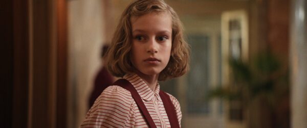 Kadr z filmu. Młoda dziewczynka patrzy gdzieś z niepokojem.