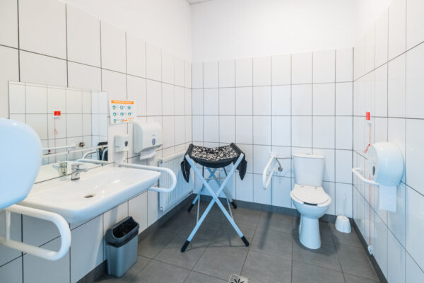 Toaleta dla osób z niepełnosprawnością. W środku przewijak dla niemowlaków.
