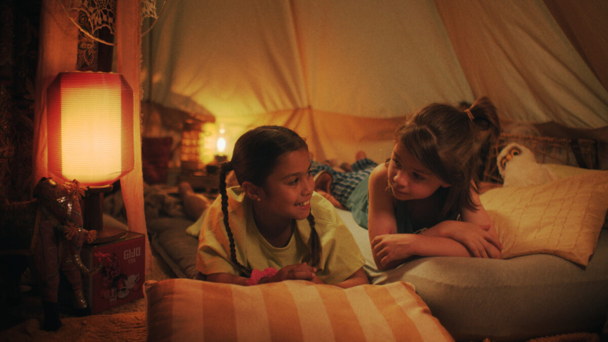 dwójka dzieci rozmawia leżąc na kocach