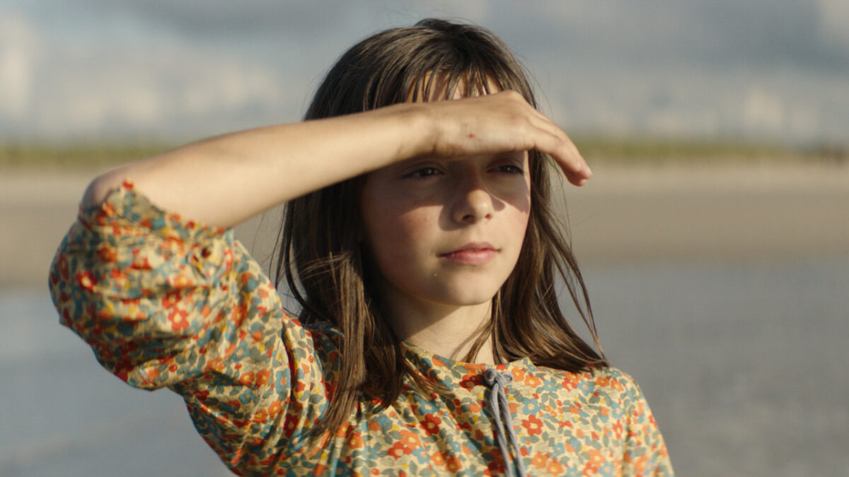 Dziewczyna osłania oczy ręką przed słońcem