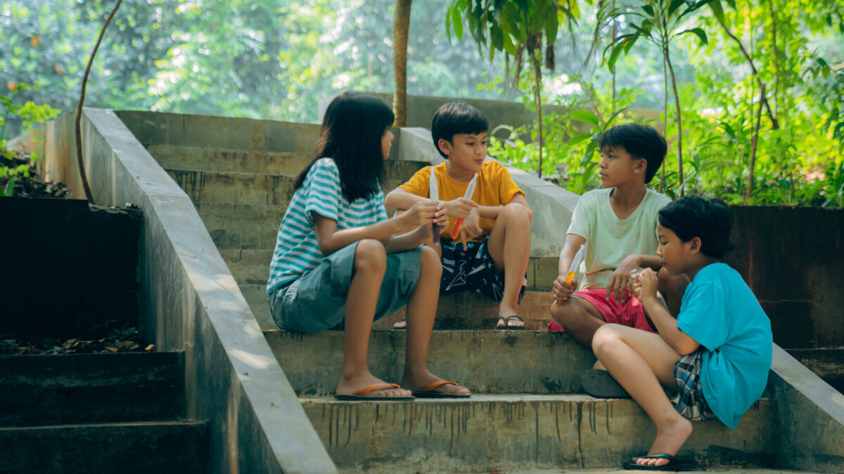 czwórka dzieci siedzi na schodach