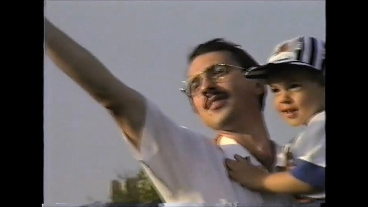 mężczyzna trzyma dziecko na rękach i wskazuje w niebo