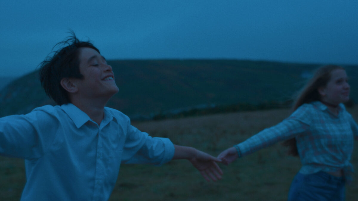 Chłopak biegnie z dziewczyną za rękę na łące