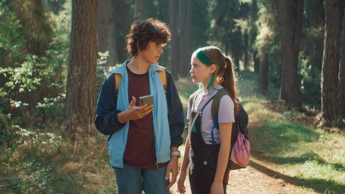 dziewczyna i chłopiec stoją w lesie, spoglądając na siebie