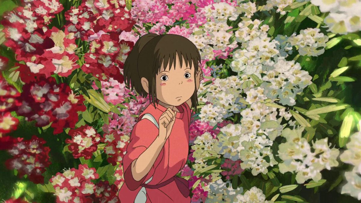 Animowana dziewczynka stoi wśród krzaków z kwiatami