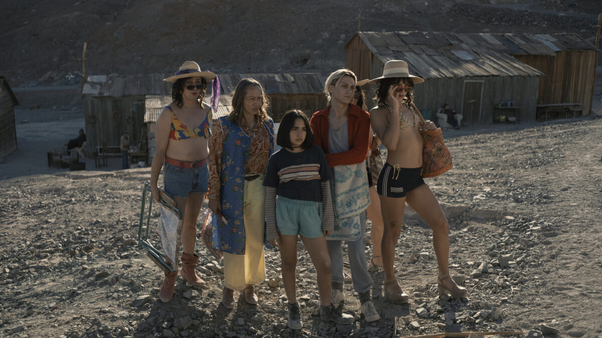 Pięć osób w plażowych strojach stoi razem