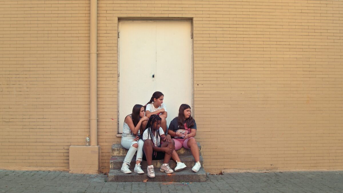 grupa nastolatków siedzi na krawężniku