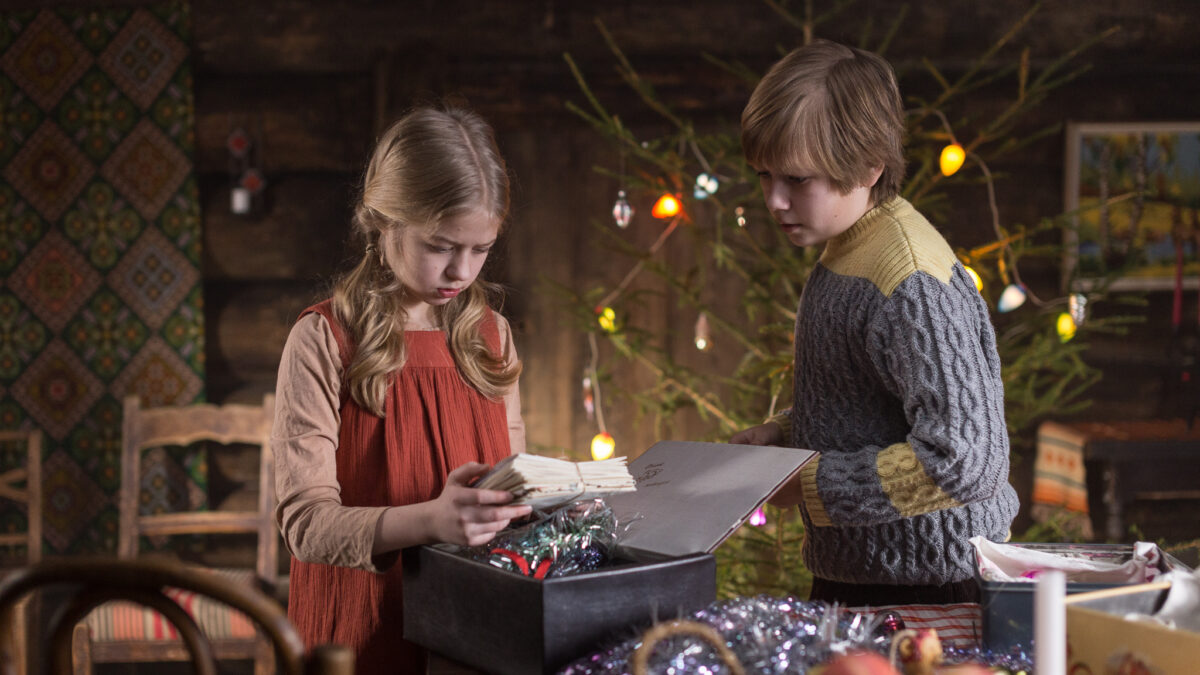 Chłopczyk i dziewczynka patrzą razem na książkę, którą trzyma dziewczynka