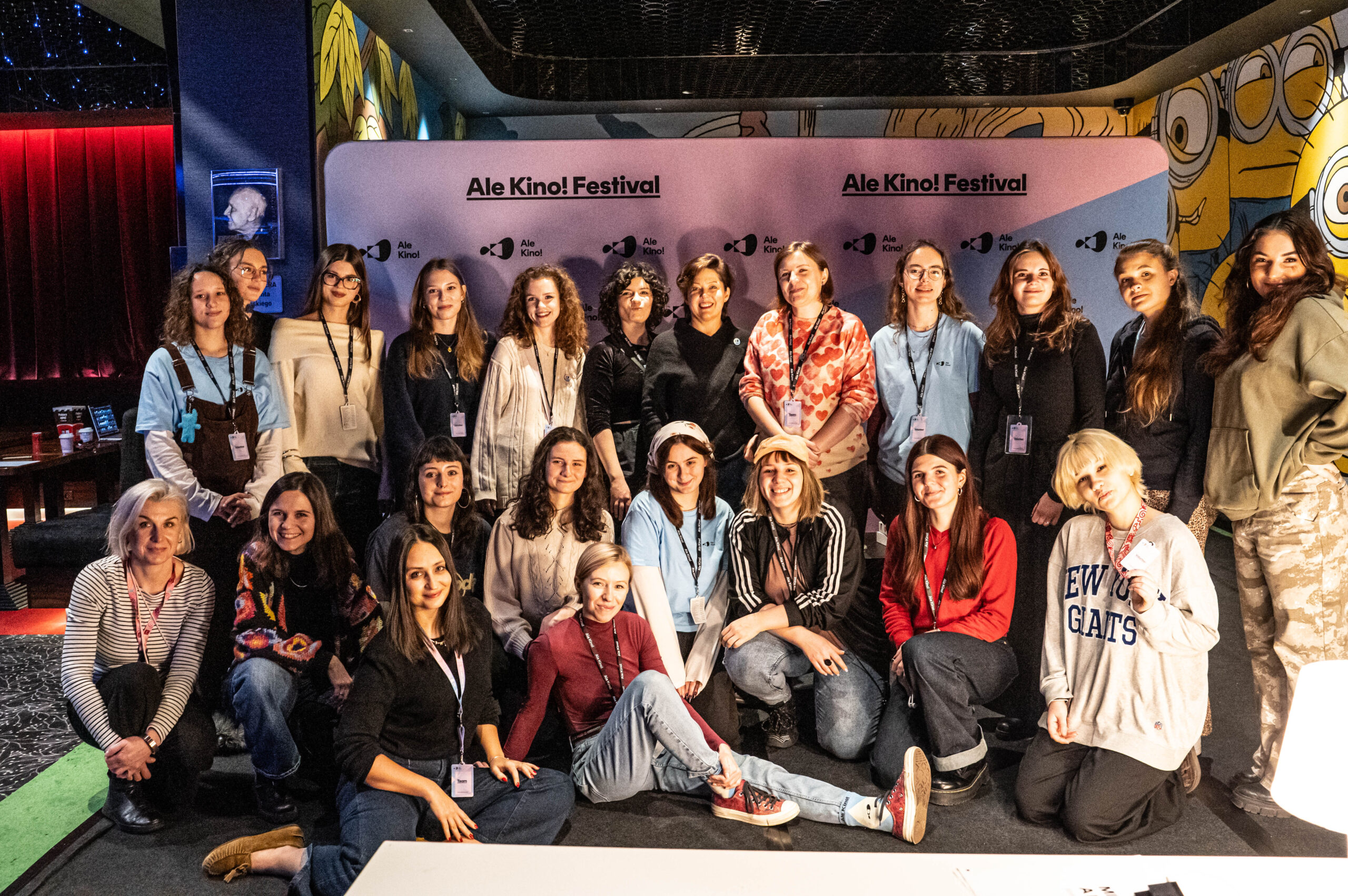 grupa wolontariuszy i wolontariuszek pozuje do zdjęcia na ściance