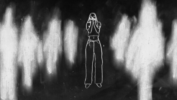 Kadr z filmu animowanego, biała, narysowana postać stoi na ciemnym tle, a wokół niej widoczne są rozmyte sylwetki innych postaci.