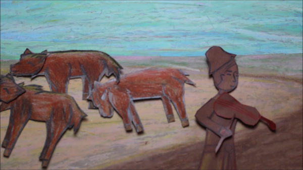 Kadr z filmu animowanego, papierowa postać grajka stoi na polu obok kilku brązowych koni pasących się na tle jasnego nieba.