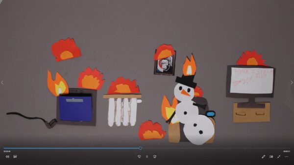 Kadr z filmu animowanego ukazuje wycięte z papieru elementy ognia oraz postać bałwana w pomieszczeniu.