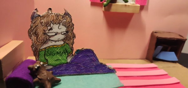 Kadr z filmu animowanego, rysunkowa dziewczynka siedzi na łóżku przykryta kołdrą, obok leży pluszowa zabawka, a wokół znajdują się meble w pokoju.