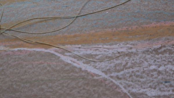 Kadr z filmu animowanego, zimowy krajobraz w jasnych odcieniach z zarysowaną ścieżką prowadzącą przez zaśnieżone pole.