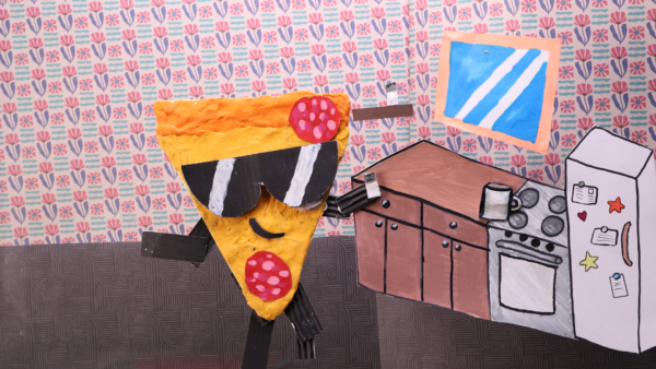 Kadr z filmu animowanego, kolorowa postać przypominająca kawałek pizzy z okularami przeciwsłonecznymi stoi w kuchni obok szafek i lodówki.