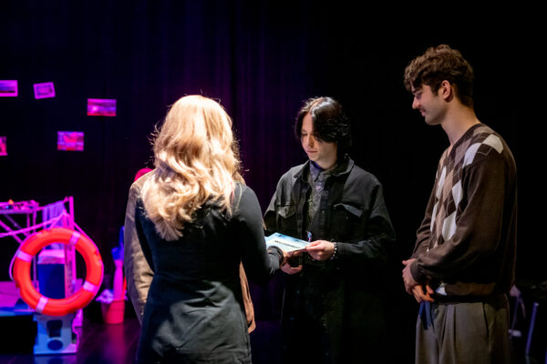 tzrej nastolatkowie odbierają nagrody z rąk kobiety